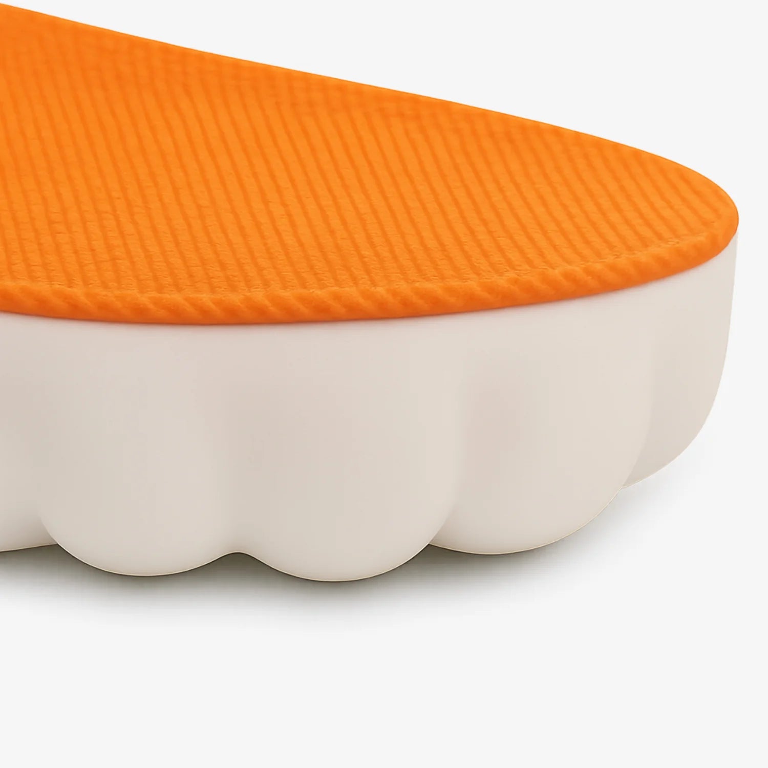 Detailansicht der SoftStep Einlegesohle mit orangefarbener Oberfläche und weißer, dämpfender Unterseite für Komfort und Entspannung