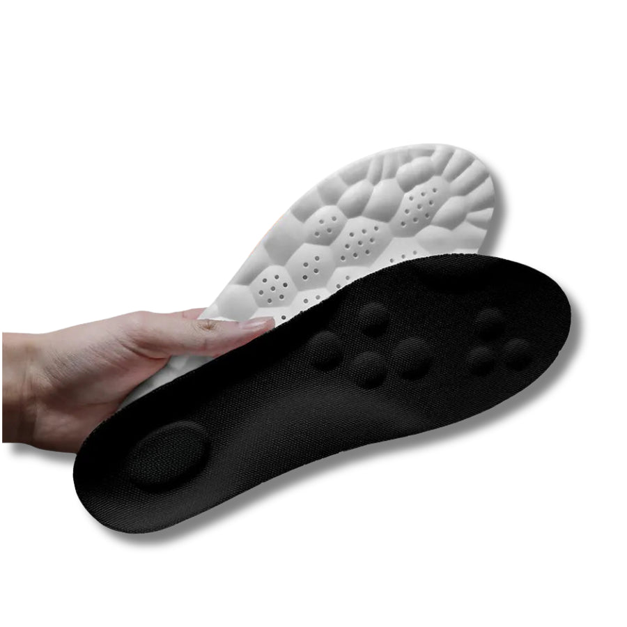 SoftStep Einlegesohlen in Schwarz und Weiß mit ergonomischen Massagepunkten und wabenförmiger Unterseite, in der Hand gehalten